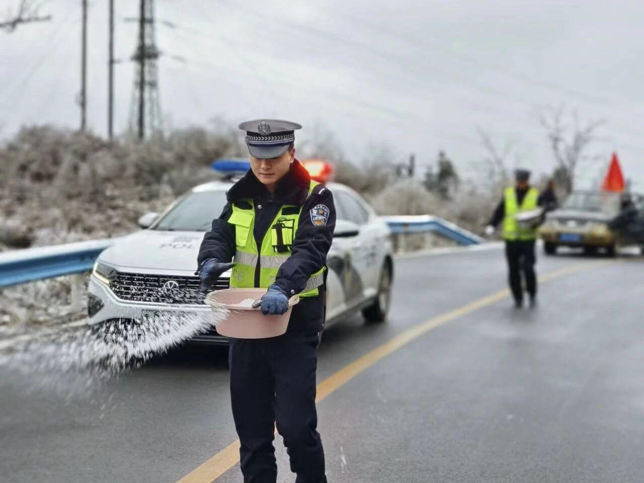 圖1民警在轄區(qū)結(jié)冰路段開展撒鹽除冰防凍工作。.jpg