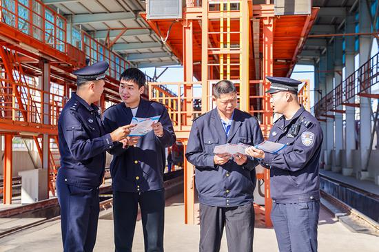 刑警支隊(duì)民警向企業(yè)職工發(fā)放宣傳資料并“一對(duì)一”講解電詐常識(shí)。謝仁古力·托呼提 攝